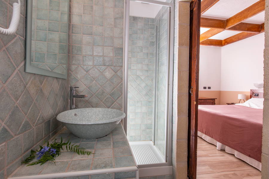 Bagno con lavabo in pietra e piastrelle artigianali